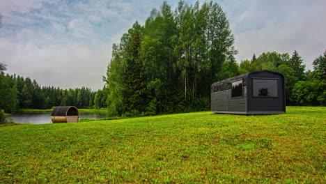 Acogedores-Edificios-De-Sauna-De-Madera-En-La-Costa-Del-Lago-En-El-área-Rural,-Lapso-De-Tiempo-De-Fusión