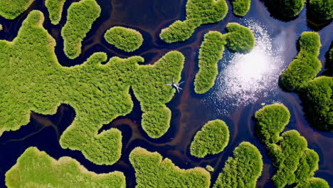 aerial view of a plane flying over green islands in water