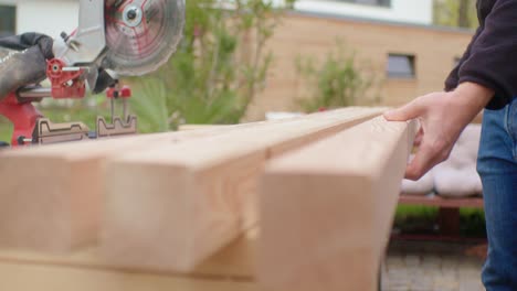 the man putting the wood on the workbench