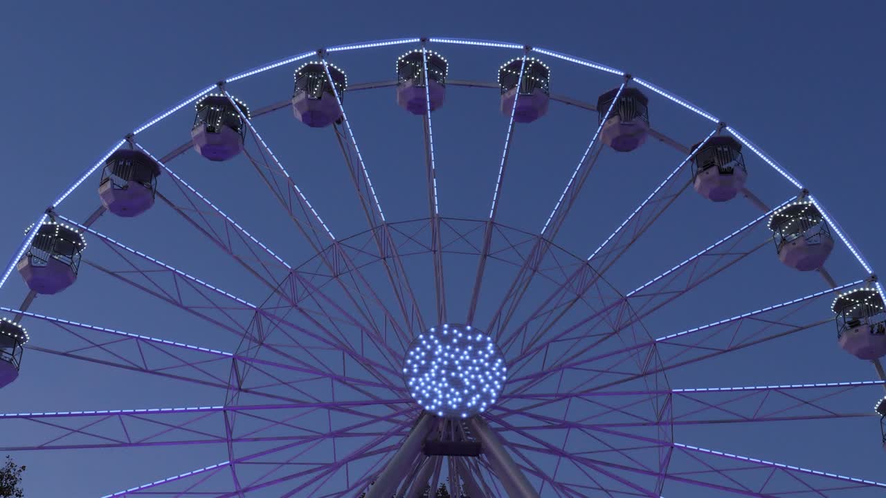 Ferris wheel in action againts a blue sky.