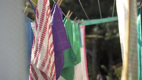 colored face towels hanging on clothesline drying in the sun outdoor