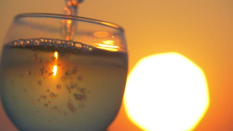 Bei-Sonnenuntergang-Wasser-In-Das-Glas-Gießen