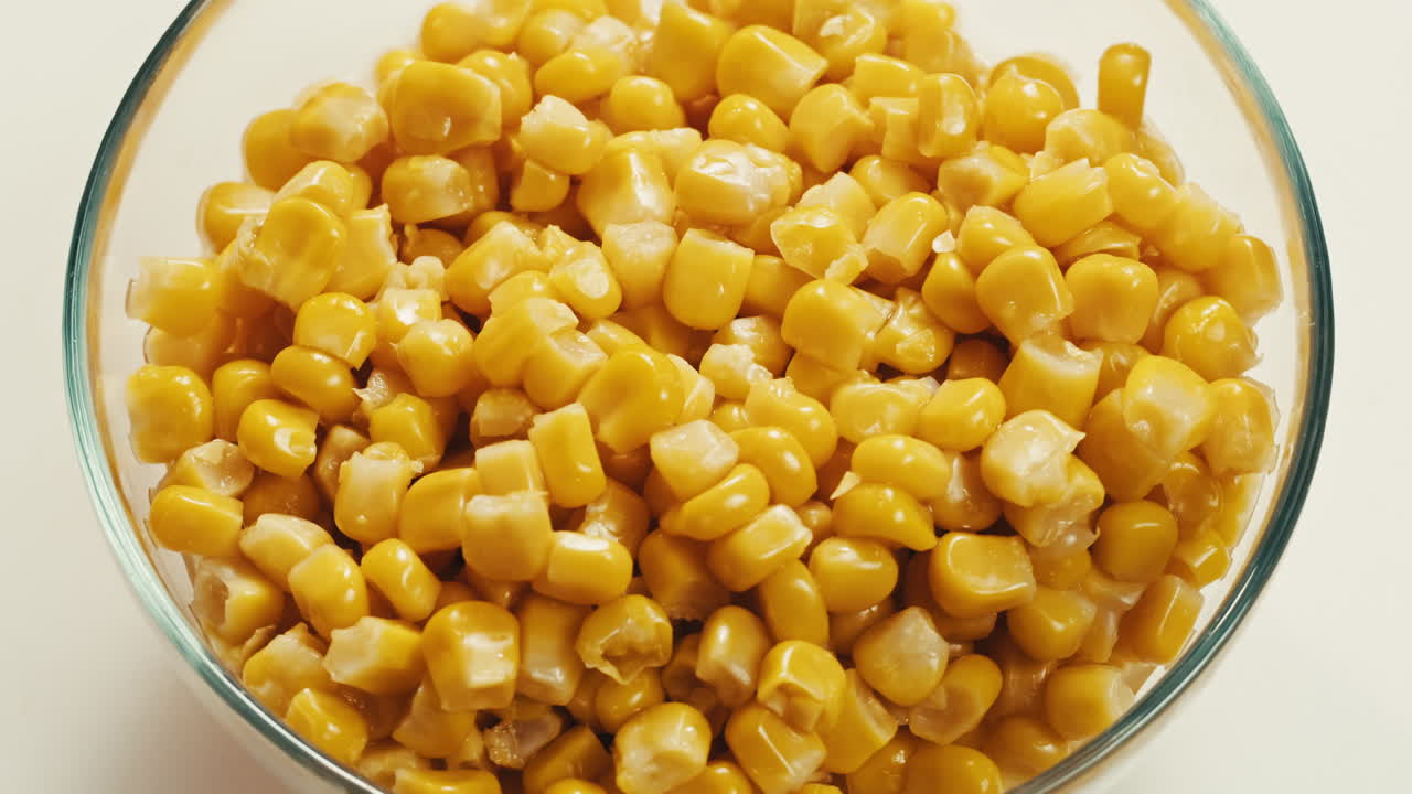 Canned corn rotating on dark background. Close up on opened aluminum can with corn. High quality 4k footage