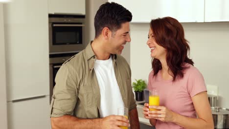 Pareja-Joven-Charlando-Y-Bebiendo-Jugo-De-Naranja