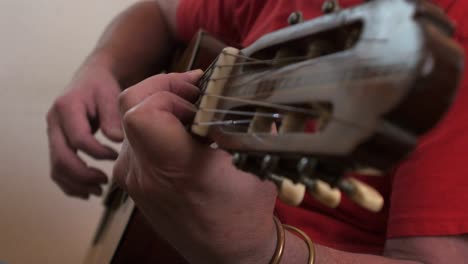 a musician plucking and strumming on a spanish guitar close up