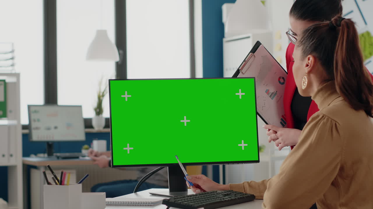 Colleagues working with green screen on display