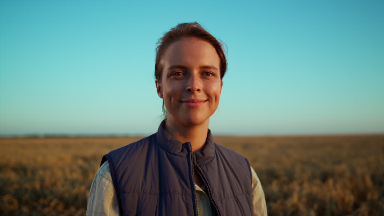 retrato de un granjero sonriente posando en un campo de grano. hermosa vista del paisaje rural.
