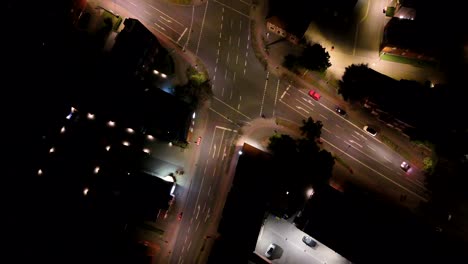 Junction with cars in American city at night. Lighting lantern and streetlamps. Turning into street. Aerial top down shot