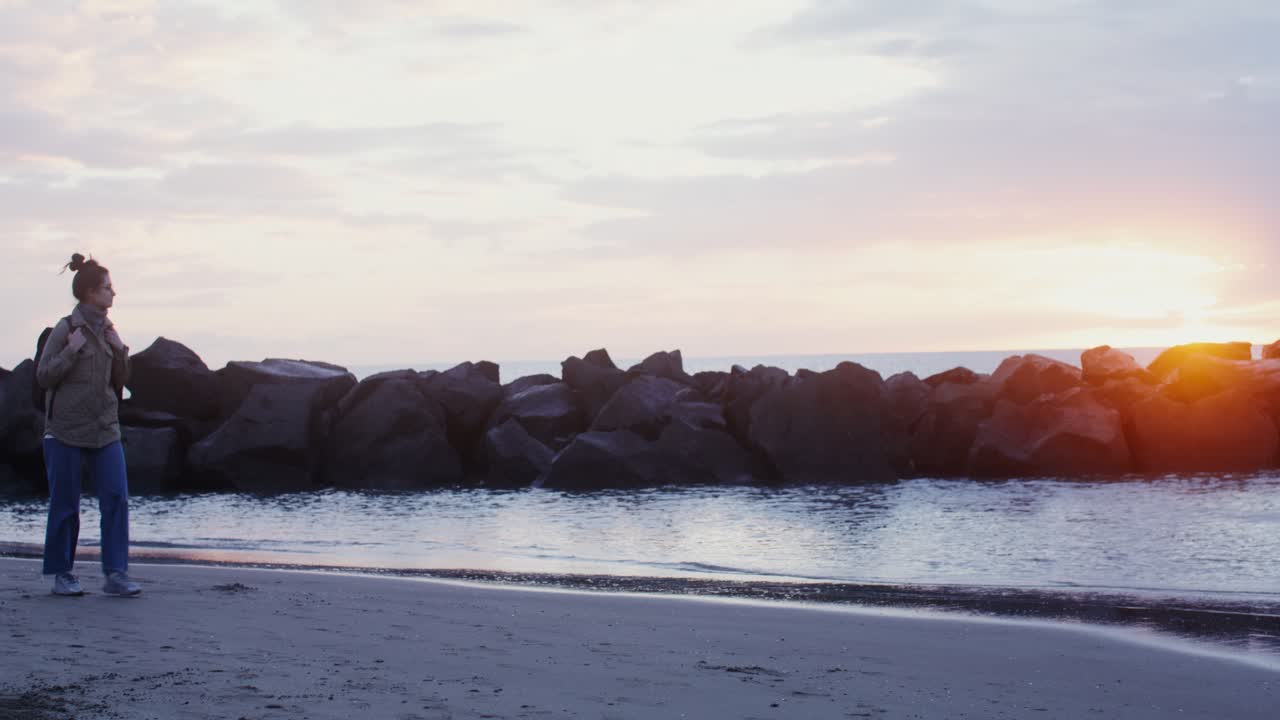 해가 뜨는 해변에 있는 여자