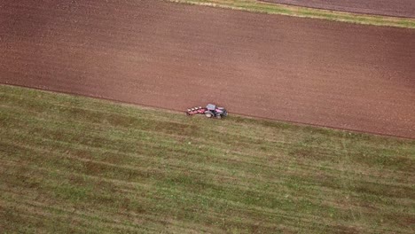 un tractor en smiltene, letonia arando el campo de un gran agricultor, vista aérea extremadamente amplia
