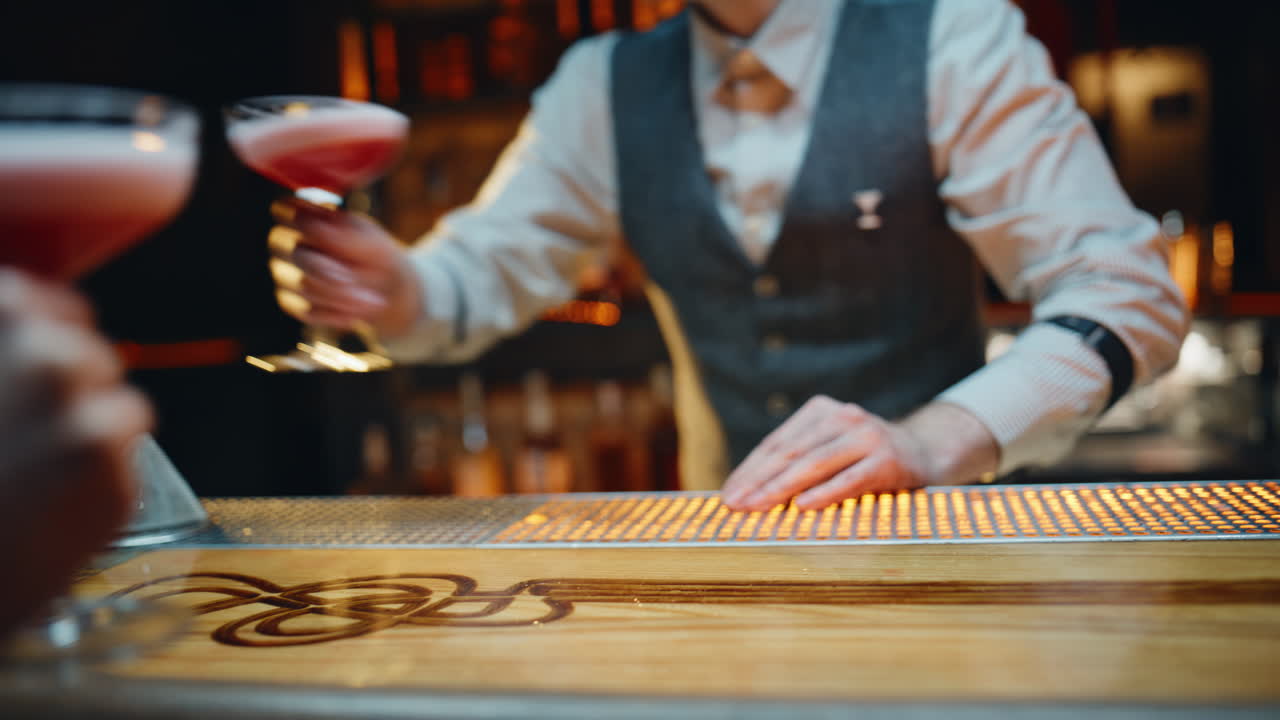 Unknown bartender presenting cocktails standing surface warm lighting closeup