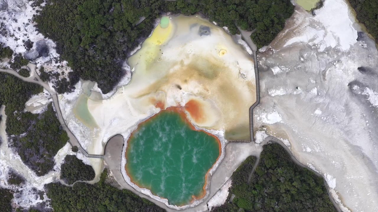 Letecký pohled na Champagne Pool obklopený ledovou krajinou. Záběr dronem na geotermální jezero v Rotorua, Bay of Plenty, Severní ostrov.