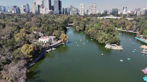 chapultepec forest lake, with towering skyscrapers of polanco, cdmx