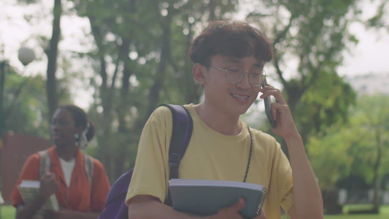 Asian College Student Walking in Park and Talking on Phone