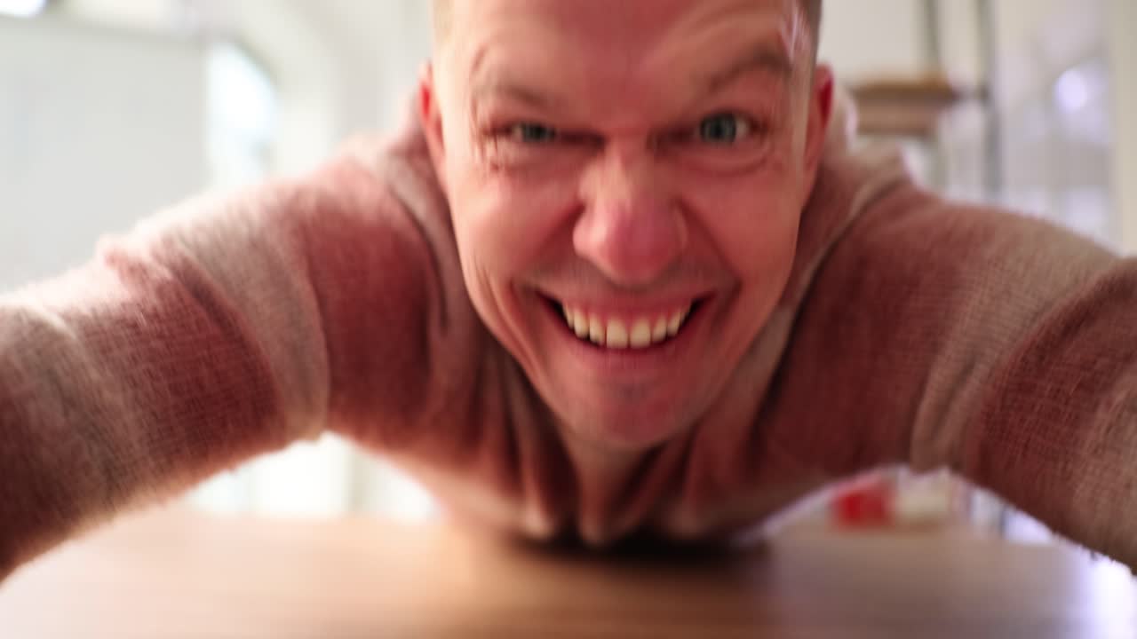 Man with intense and exaggerated expression focusing on computer keyboard