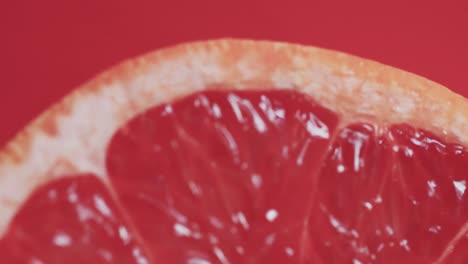 video of sliced red grapefruit with copy space over red background