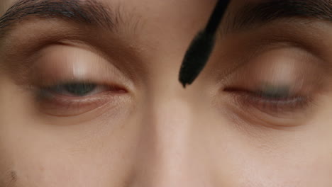 close up eyes woman applying makeup mascara using cosmetics brush macro