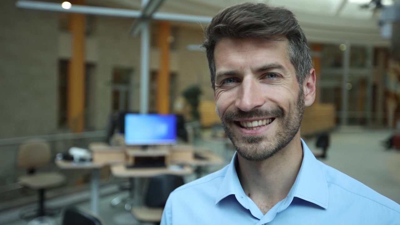 Sonriente hombre de negocios mirando a la cámara en una oficina moderna