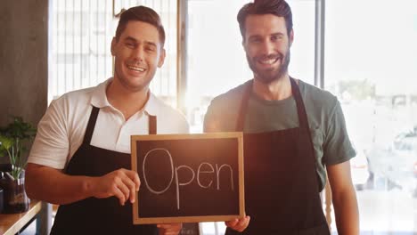 happy owner with chalkboard at counter