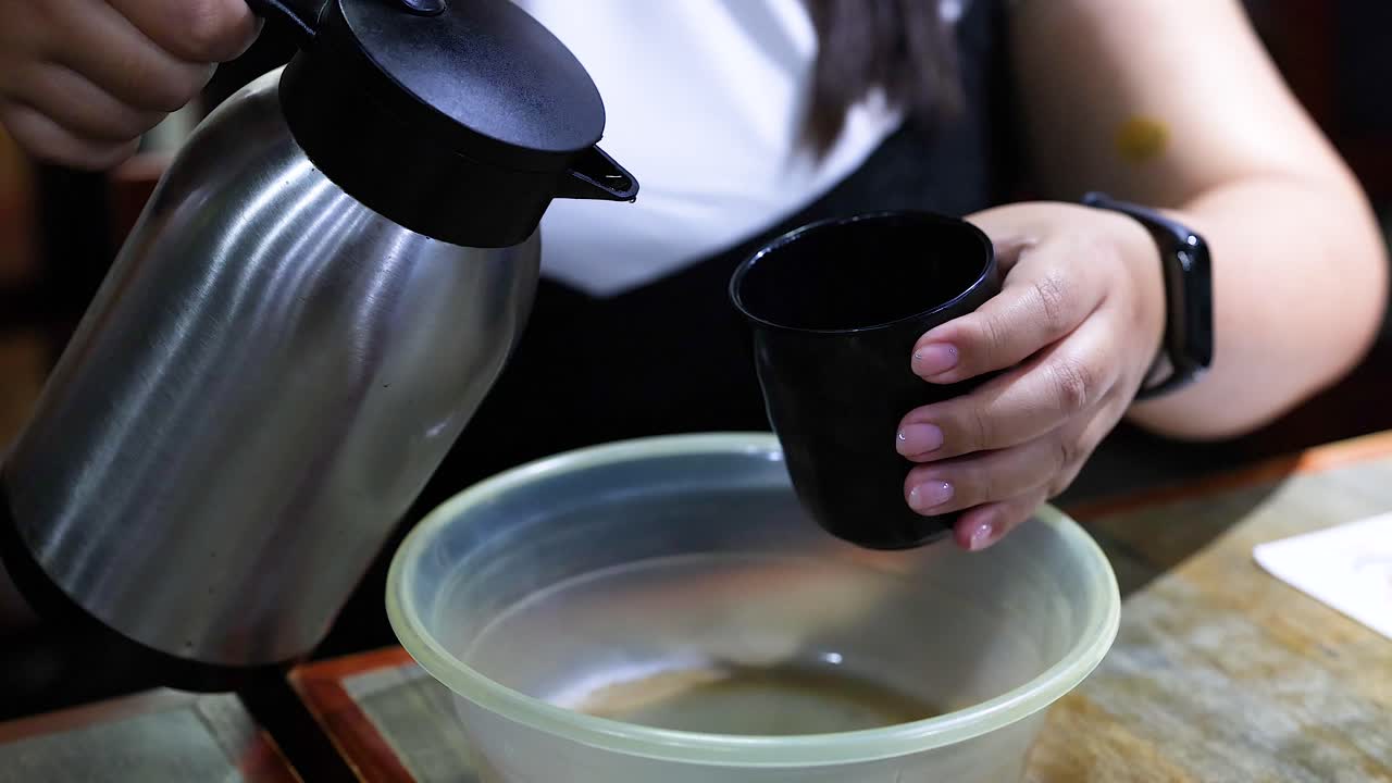 한 사람 이 테르모스 에서 물 을 그 에 부어 놓는다