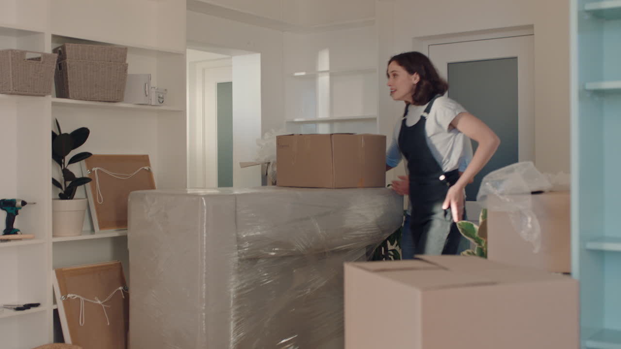 pareja joven mudándose de casa nuevos dueños de casa sonriendo disfrutando de una mudanza exitosa abrazándose en el apartamento