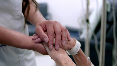 mujer sosteniendo la mano del paciente abuela mayor, vista en primer plano
