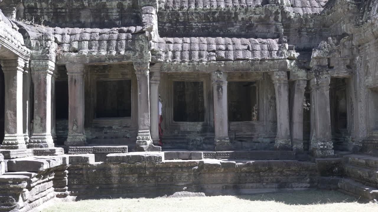 bella mujer caminando por las antiguas ruinas del antiguo templo de piedra en camboya