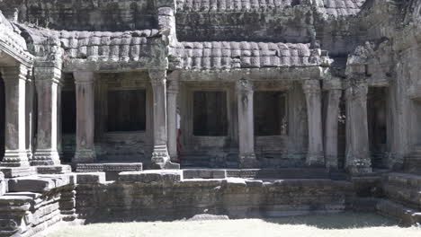 beautiful woman walking through ancient ruins of old stone temple in cambodia