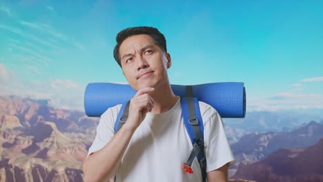 close up of asian male hiker with mountaineering backpack thinking about something and looking around while traveling at the top of mountain