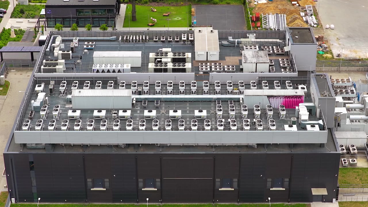 Aerial view of a modern data center building, highlighting the numerous hvac units on the roof for cooling the powerful gpu servers inside