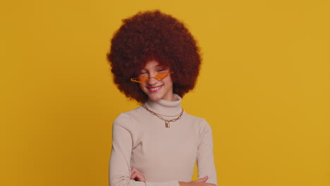 Cheerful-lovely-young-teenager-child-girl-kid-smiling,-looking-at-camera-on-studio-yellow-background