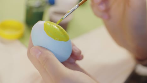 close up of decorating blue easter egg