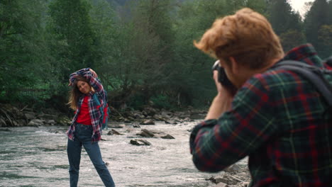 woman posing at camera on river shore