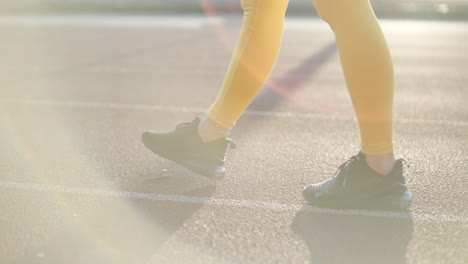 woman jogging on outdoor track in sportswear at athletic field