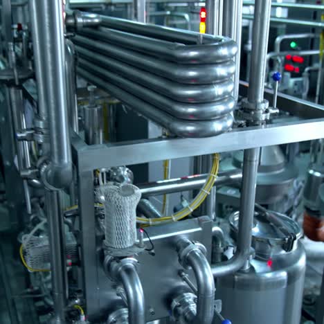 milk and water pipelines at a modern dairy factory. tanks, pipes and faucets close up. gradual lifting above the factory equipment