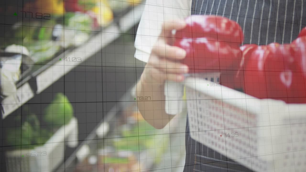 Female grocery clerk selecting red pepper, checking freshness while green graphs overlaying shelf