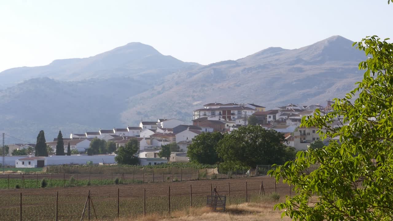 Traditionella vita hus i Zafarraya, inbäddade vid foten av höga berg. Typisk andalusisk arkitektur omgiven av jordbruksmark och orörd natur