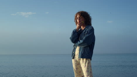 Fashionable-girl-thinking-on-ocean-shore.-Pensive-woman-holding-hand-on-face