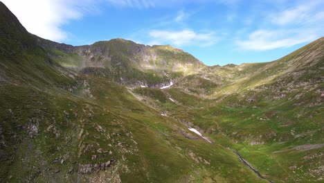 Sunrise-view-over-Moldoveanu-and-Vistea-Mare,-Fagaras-Mountains-with-vibrant-sky-and-rugged-terrain,-aerial-shot