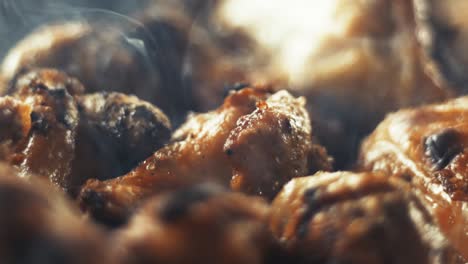 slow motion close-up shot of chicken wings and smoke from the charcoal grill