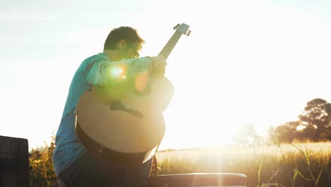 musician takes guitar out of case at sunset slow motion