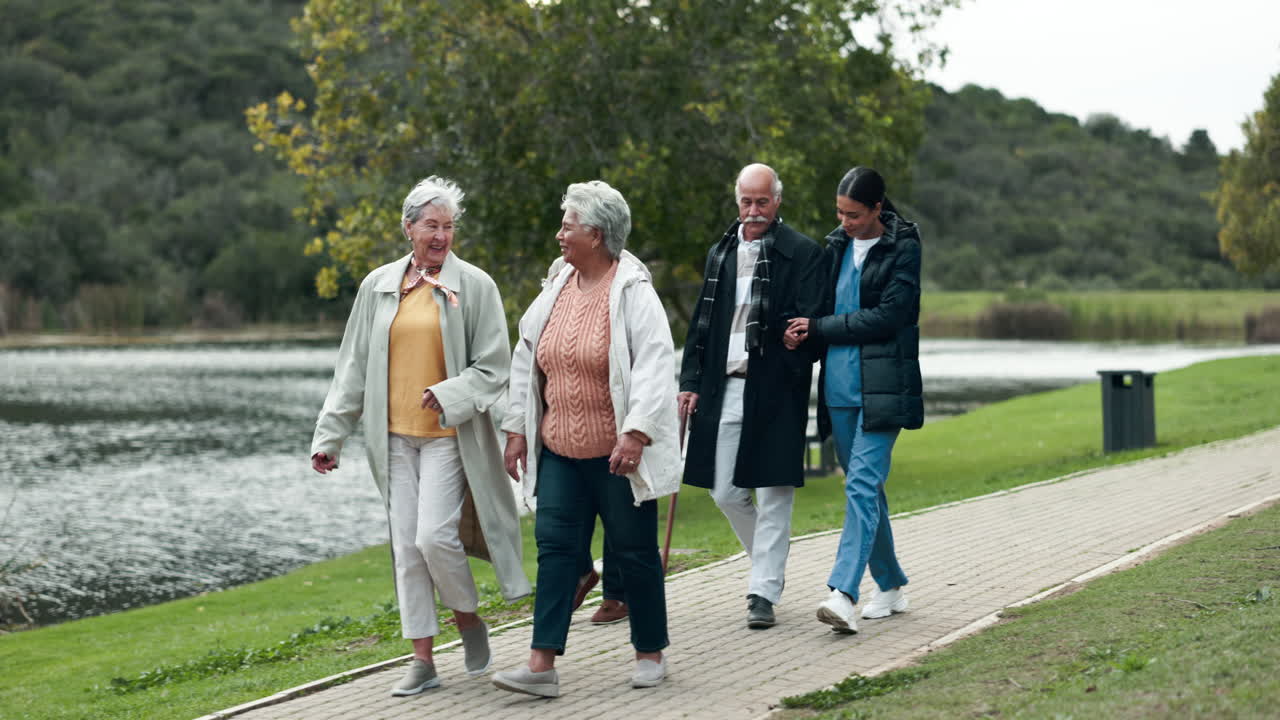 Seniors enjoying a walk in the park with caregiver