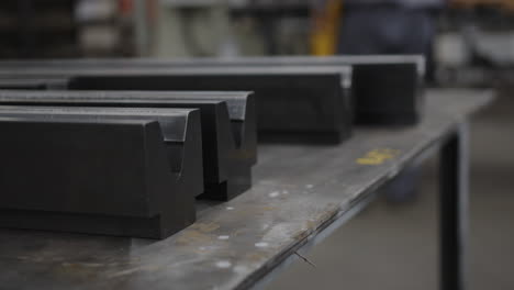 Close-up-of-metal-profiles-on-a-workbench-in-an-industrial-workshop,-shallow-depth-of-field