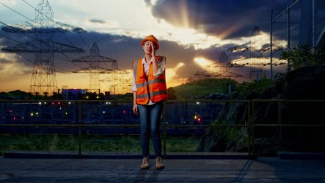 full body of asian female engineer with safety helmet yelling with hand over mouth while standing near high voltage tower