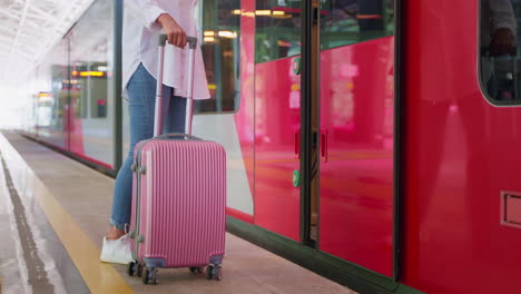 woman with suitcase waiting for a train