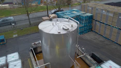 huge container at an industrial oil factory beside road, supply vehicle passing - high angle static shot