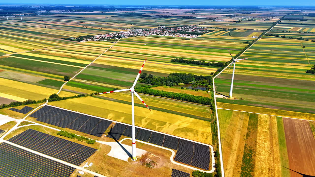 Rural wind and solar energy. Wind turbines and solar panels are spread across a vast rural area, showcasing renewable energy sources in action