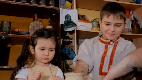 potter showing how to work with ceramic in pottery studio