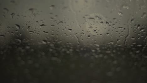Close-up-of-rainwater-droplets-on-glass.-Handheld