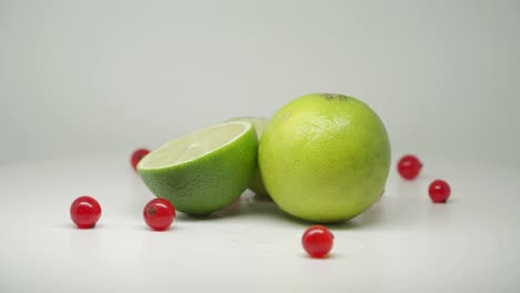 Frische-Grüne-Limette,-Eine-Horizontal-Geschnitten-Mit-Roten-Johannisbeeren---Nahaufnahme